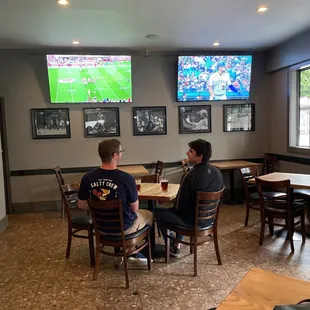 two men sitting at a table in a sports bar