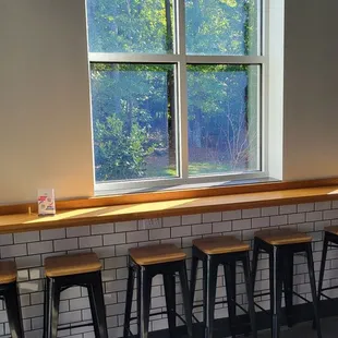 a row of stools in front of a window