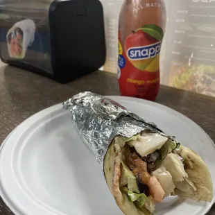 Falafel wrap with fries inside and a mango Snapple. So fresh so tasty! Mouth watering. Homemade hummus falafels tahini and crinkle fries!