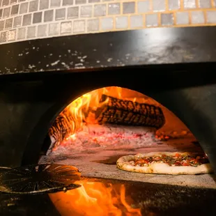 Wood-fired pizza being cooked.