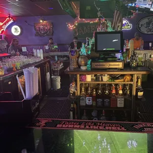  a bar with neon lights and a television
