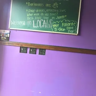  a purple wall with a blackboard on it
