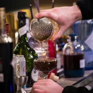 a bartender pouring a drink at a bar