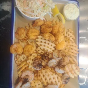 Fried and grilled shrimp with coleslaw, waffle fries, and sauce