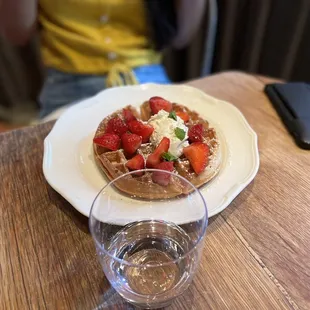 a waffle with strawberries and whipped cream