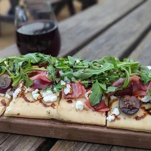 a flatbread pizza on a wooden board