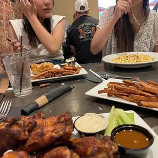 two women sitting at a table with plates of food