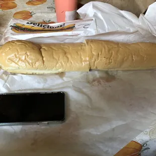 Whole steak and cheese sub.  iPhone X for scale.