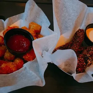 two baskets of food with dipping sauce