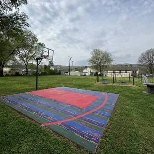 Basketball court with lines and large hoop with breakaway rim 9 foot 9 inches rim - painted by local mural artist