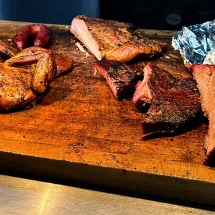 a cutting board with meat and potatoes