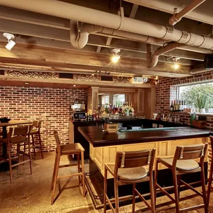 a brick bar with wooden chairs