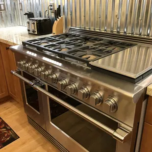 Gas stove with 6 burners and griddle.