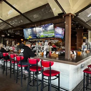 a bar with red chairs