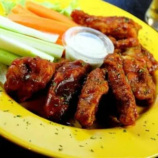 a plate of chicken wings with celery and carrots