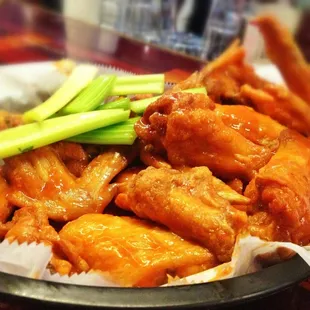 a plate of chicken wings with celery