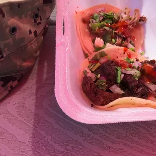 two tacos in a plastic container