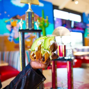 a person holding a sandwich in a restaurant