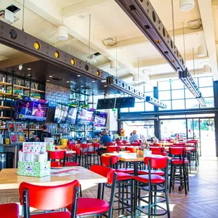 the inside of a restaurant with red chairs