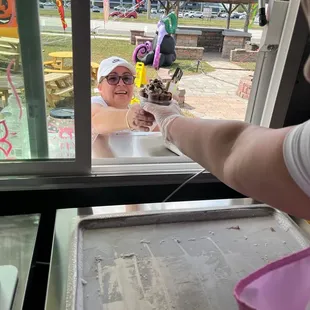 a woman serving an ice cream sundae