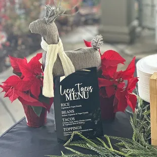 a table with a menu and poinsettis