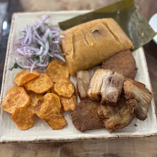 Chicharrón, camote frito, tamal y salsa criolla