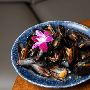 a plate of mussels with a flower