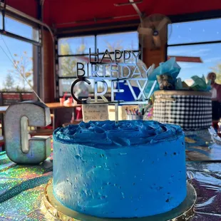 a blue birthday cake on a table