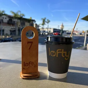 a cup of coffee and a sign for lofty