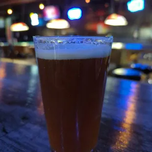 a glass of beer on a bar