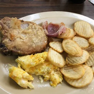 Fried pork chop, country ham, scrambled eggs and home fries.
