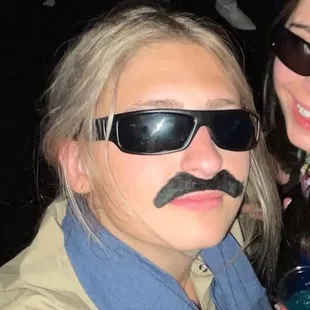 two women with fake mustaches