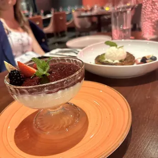 a woman sitting at a table with a dessert in front of her