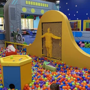 a child playing in a ball pit