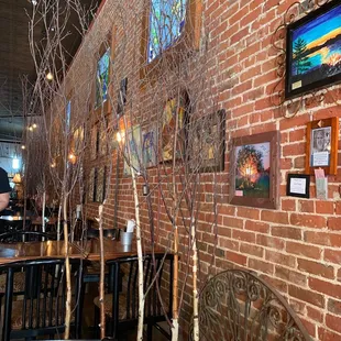 a brick wall with a variety of framed pictures