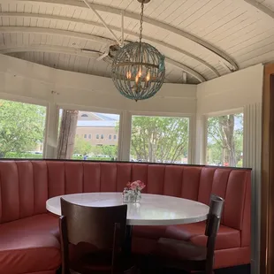 a corner booth with a table and chairs