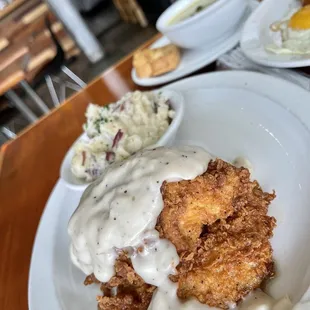 a plate of fried chicken with gravy and mashed potatoes