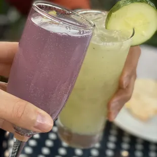 two people holding glasses of drinks