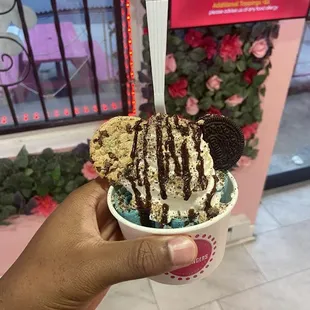 a hand holding a cup of ice cream