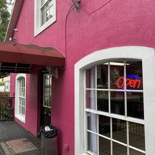 a pink building with a neon sign