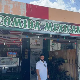 a man standing in front of a mexican restaurant