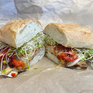 a sub sandwich with sprouts and tomatoes