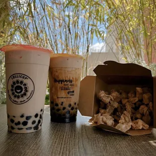two cups of bubble tea and a bag of chicken nuggies