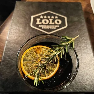 a drink with a sprig of rosemary