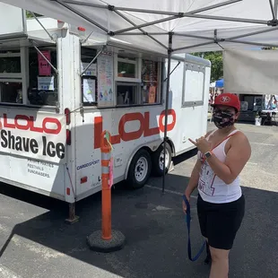 a woman standing in front of a food truck