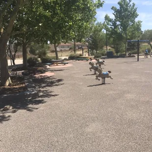 Part of playground with little picnic tables in the shade