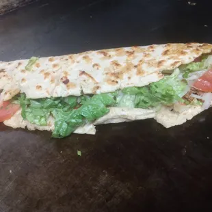 a tortilla with lettuce and tomatoes