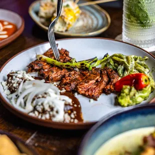 Steak Tampiqueña 
grilled strip steak / refried beans / rajas corn enchilada