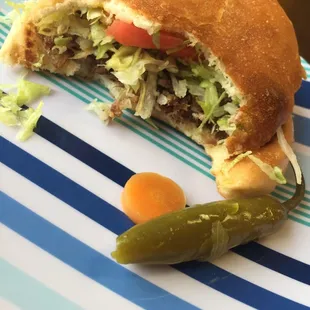 a sandwich on a plate with a pickle