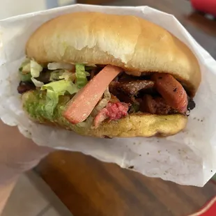 a hand holding a sandwich